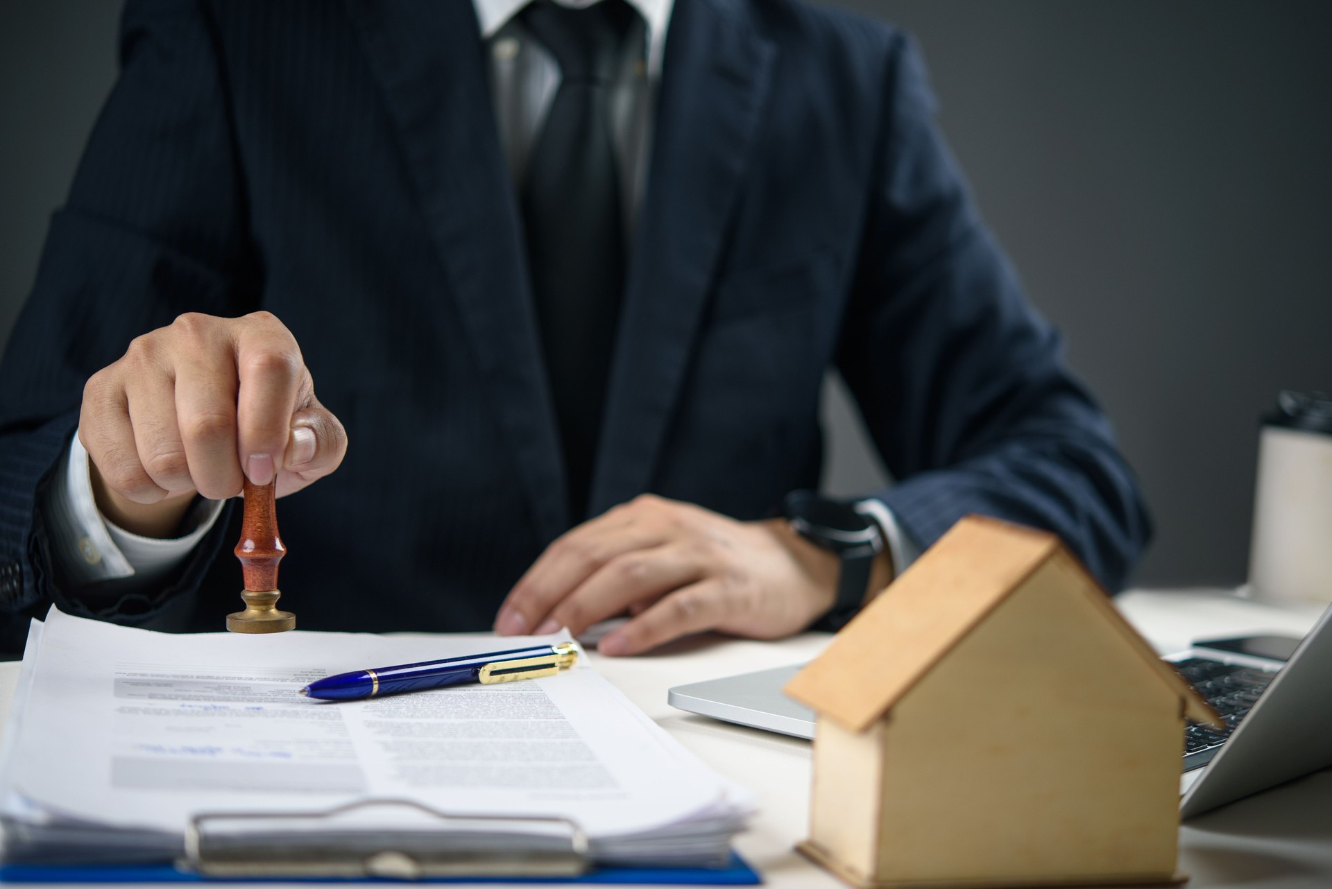 Businessman stamping approved on real estate contract. Concept of property agreement, mortgage approval, and legal documentation for home buying.